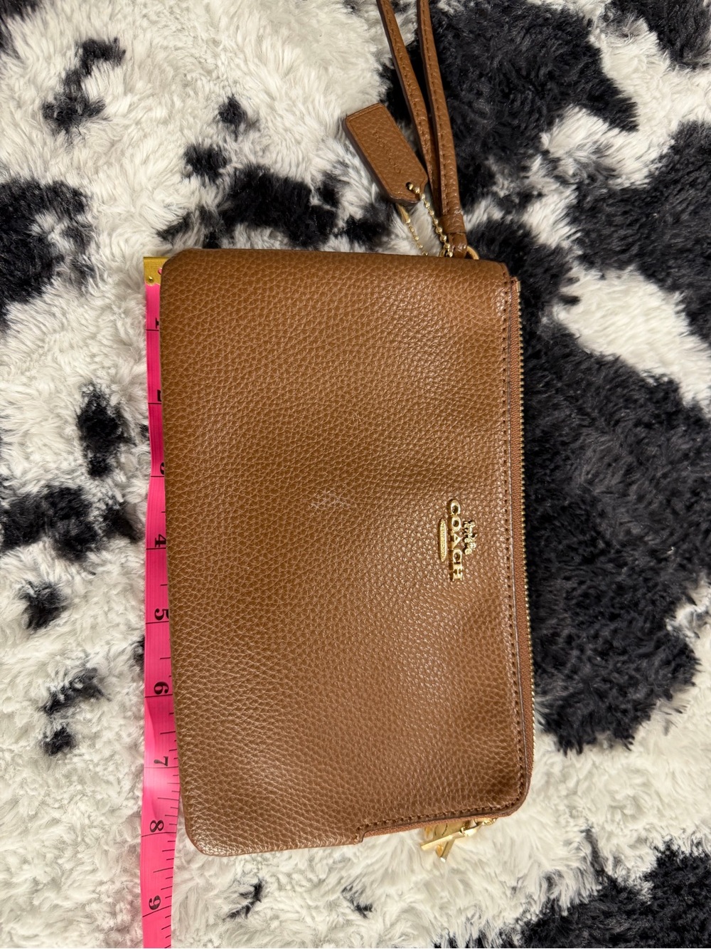 Coach a brownleather Coach wristlet wallet with gold hardware.